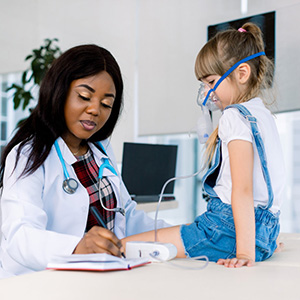 Child Wearing Oxygen Mask Sitting On Table