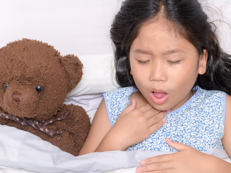 Child Coughing In Bed With Teddy Bear