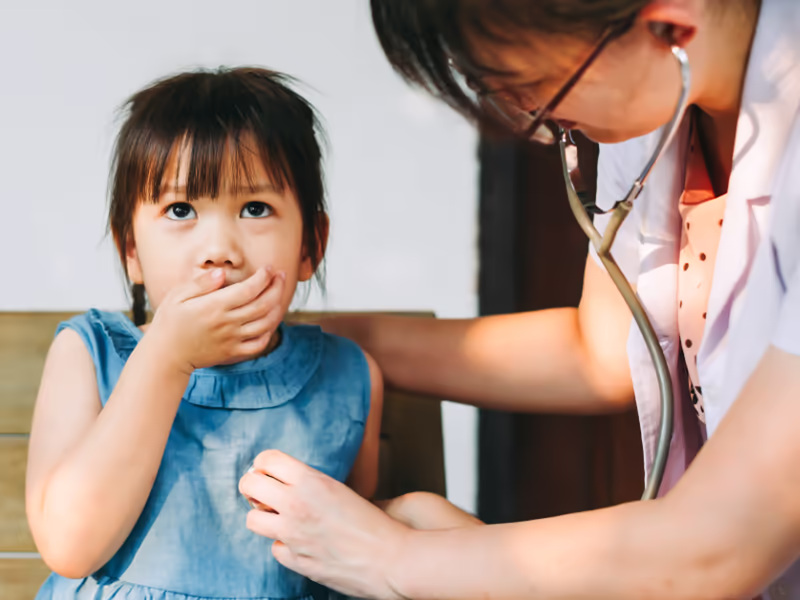 Child Coughing While Being Tended To By A Doctor