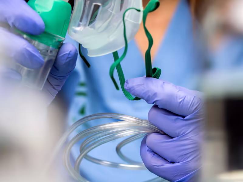 Hands In Surgical Gloves Handling A Respiratory Mask