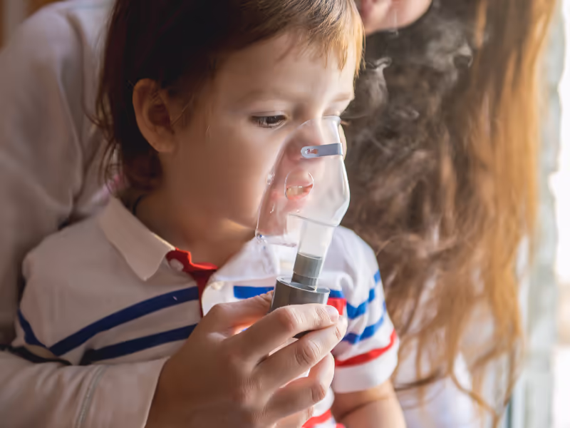 Woman Holding Nebuliser Mask Over Childs Face